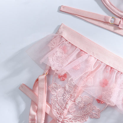 “Close-up of floral embroidery on pink mesh lingerie set