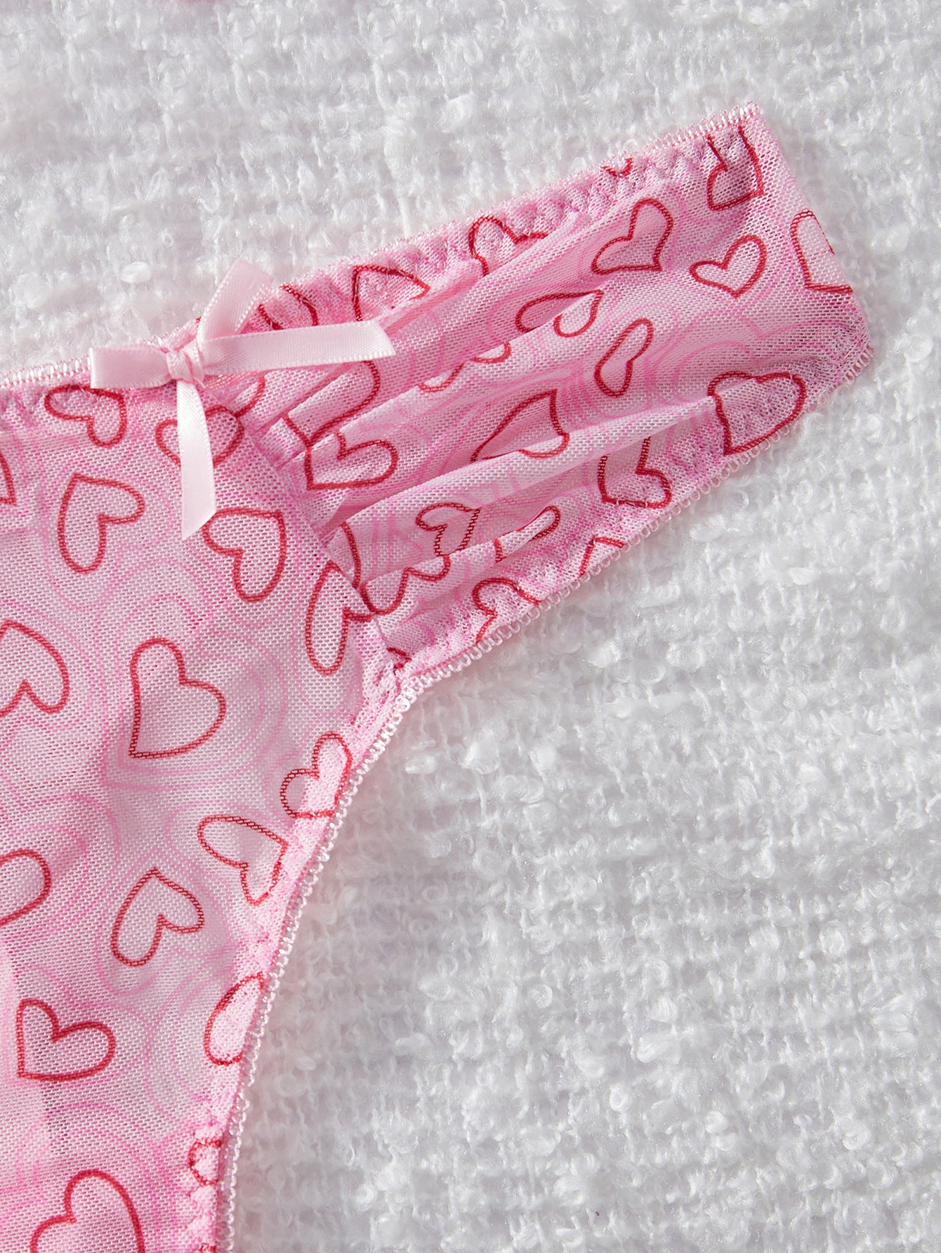 Pink underwear with red heart patterns on a white background
