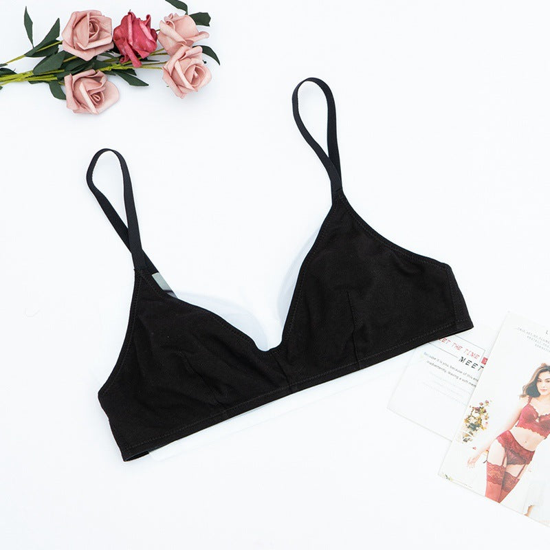 Black bralette on a white background with pink roses and a magazine.