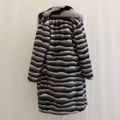 Striped fur coat on a hanger against a plain background