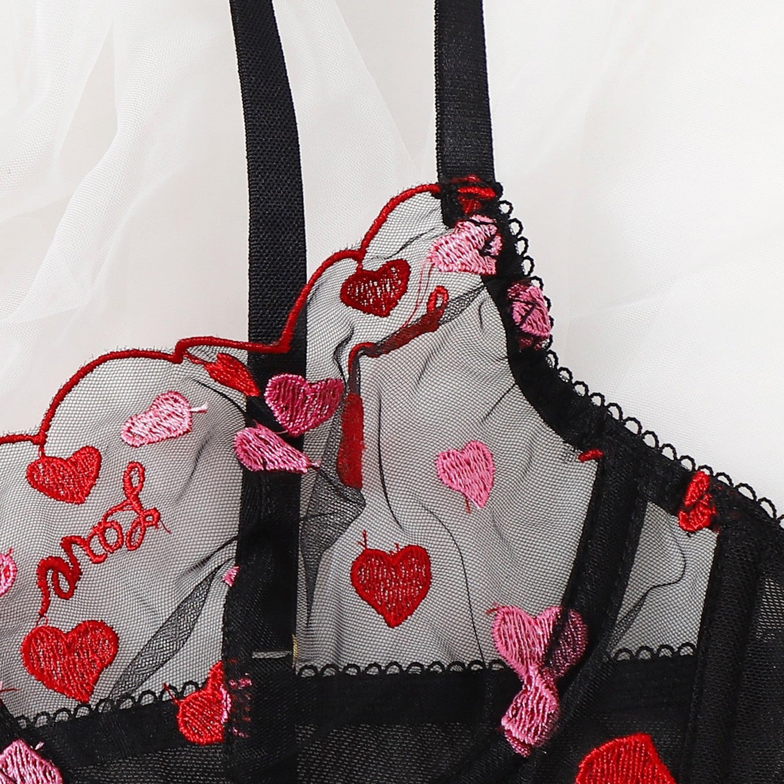 Embroidered lingerie with red and pink hearts and 'I love you' text on a white background