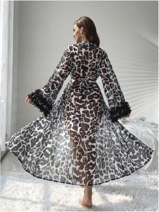 Woman wearing a leopard print dress with black fur trim in a minimalistic setting