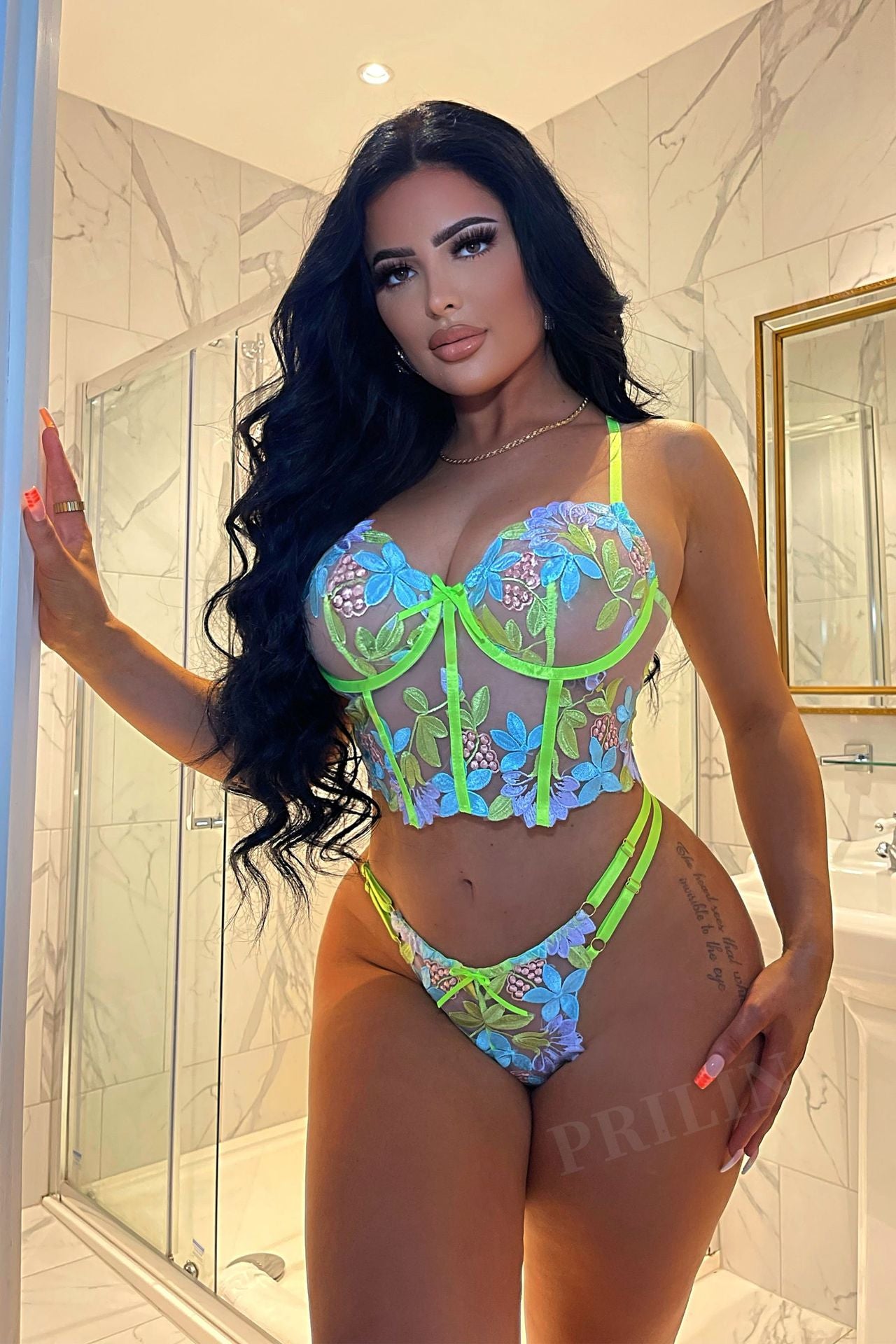 Woman wearing a colorful floral lingerie set in a bathroom.