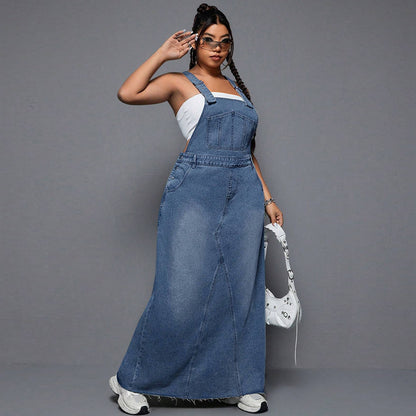Woman wearing a long denim dress against a gray background