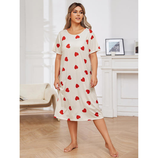 Woman wearing a white dress with red heart patterns in a room.