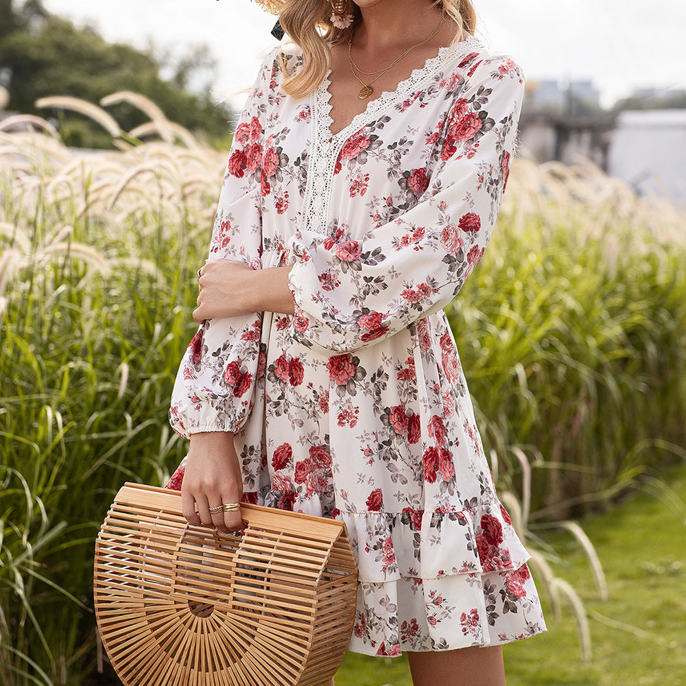 Woman in a floral dress holding a woven bag in a grassy outdoor setting