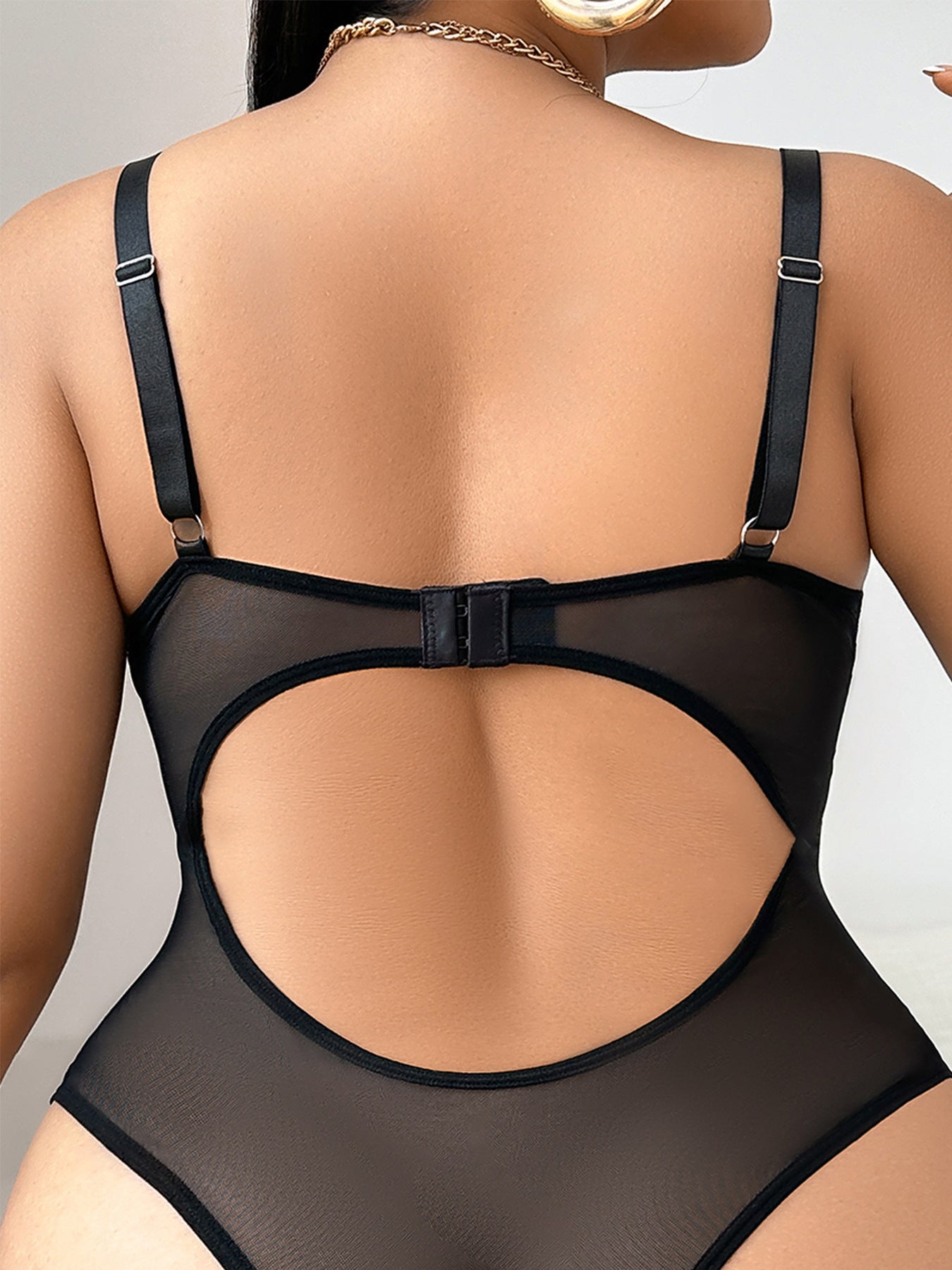 Black mesh bodysuit worn by a model on a neutral background