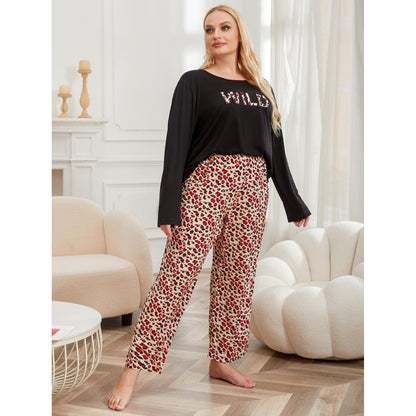 Woman wearing a black top with 'WILD' text and patterned pants in a living room.