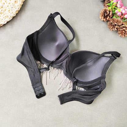 Black bralette on a light gray surface with decorative elements.