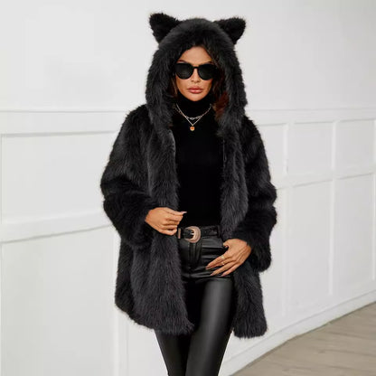 Person wearing a black fur coat with bear ears and sunglasses against a white wall.