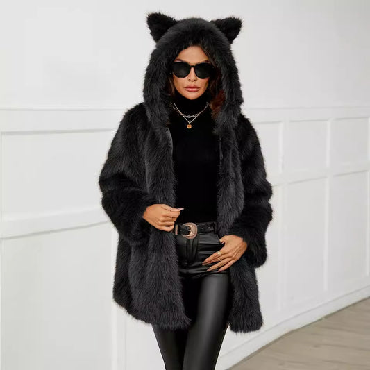 Person wearing a black fur coat with bear ears and sunglasses against a white wall.