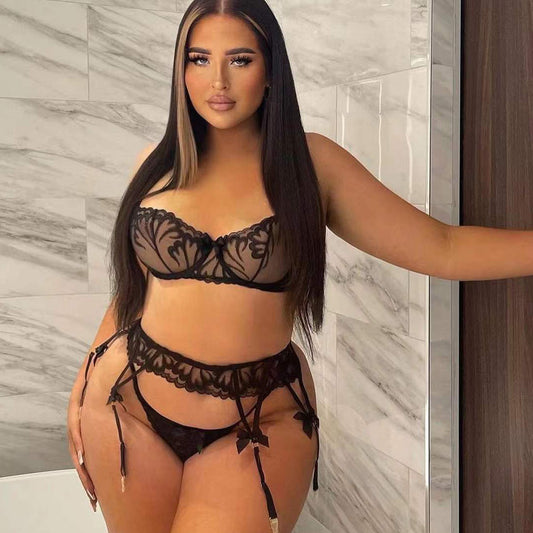 Woman wearing a black lace lingerie set in a bathroom.