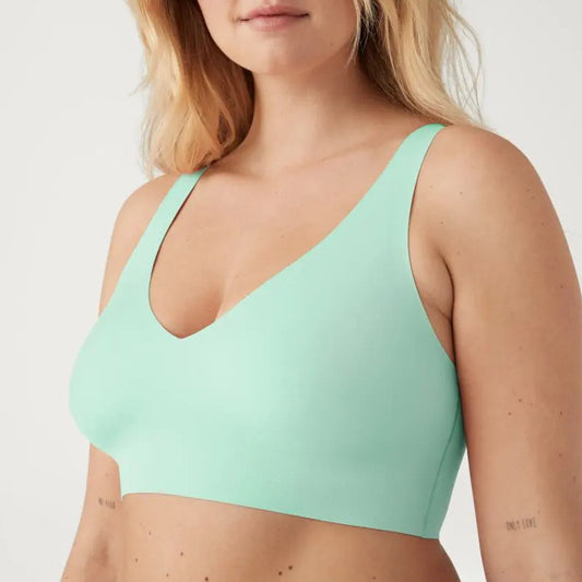 Mint green sports bra worn by a person on a plain background