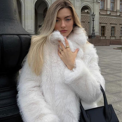 Woman wearing a white fur coat in an urban setting