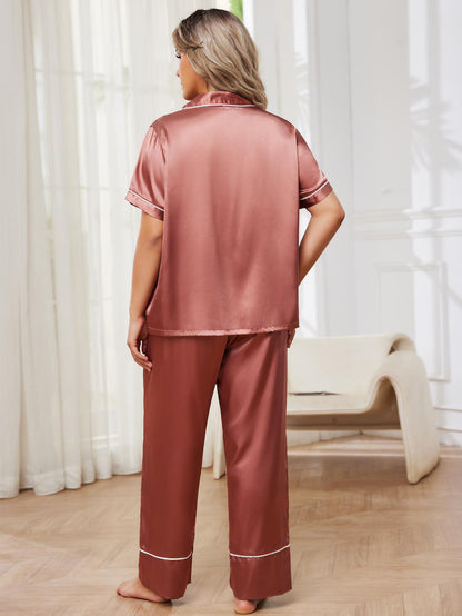 Woman wearing pink satin pajamas standing in a room with white curtains.