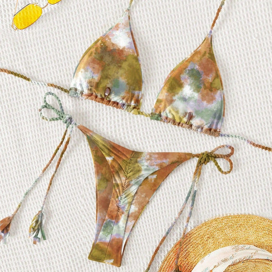 Floral bikini set with a straw hat on a textured surface