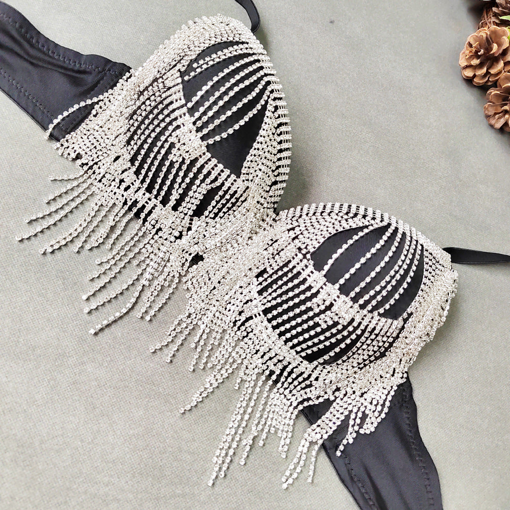 Black bikini top with white beaded fringe on a gray surface