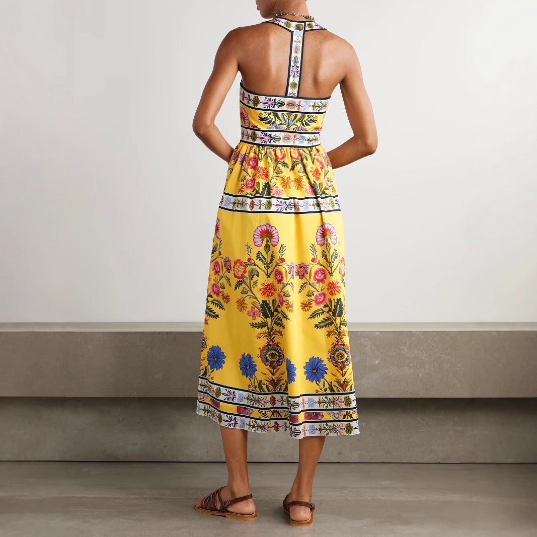 Woman wearing a yellow floral dress with a neutral background