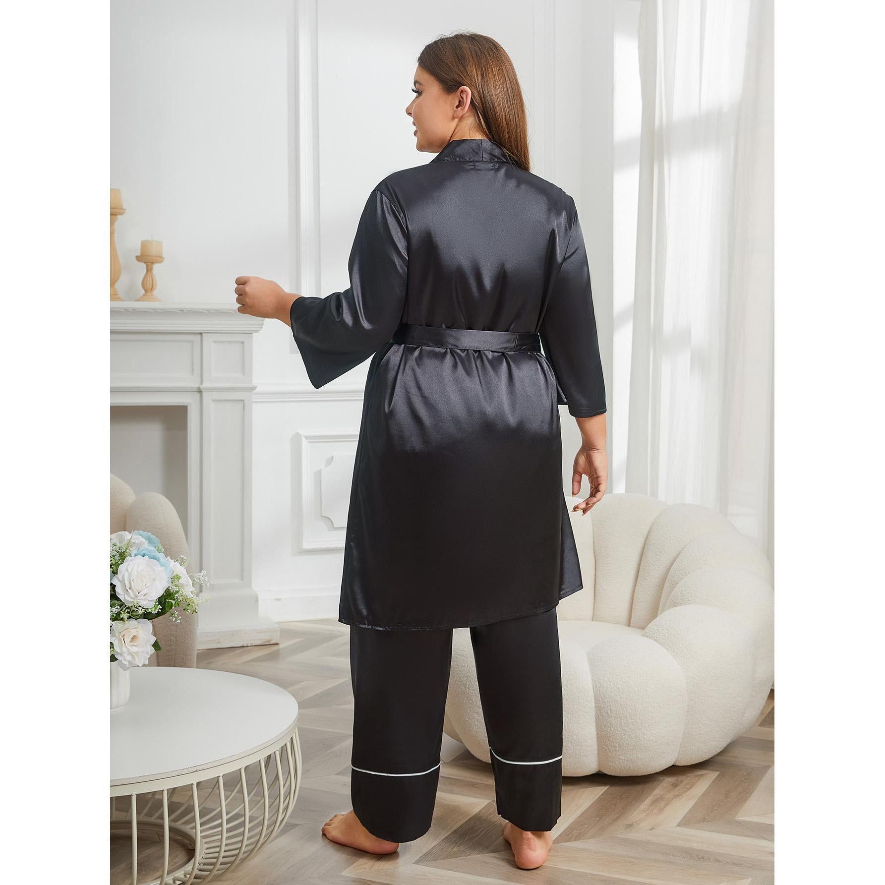 Woman wearing a black satin robe in a stylish room with a fireplace and white decor.