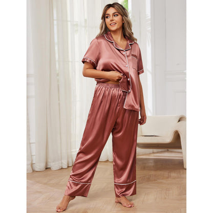 Woman wearing a pink satin pajama set in a bright room with white curtains.