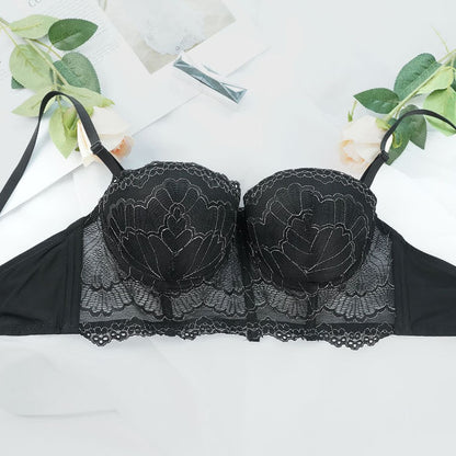 Black lace bra on a white background with green leaves