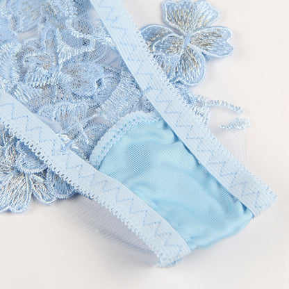 Close-up of light blue lace fabric with floral patterns on a white background