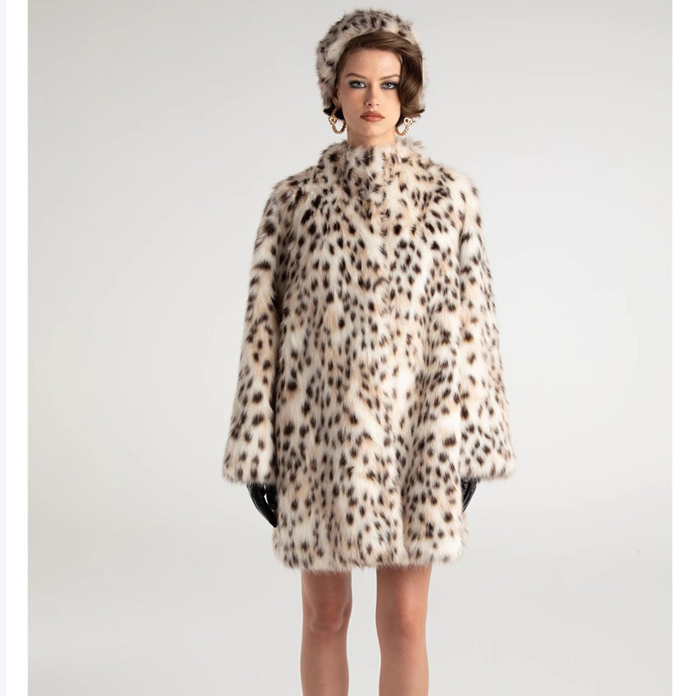 Model wearing a leopard print coat and hat on a plain background