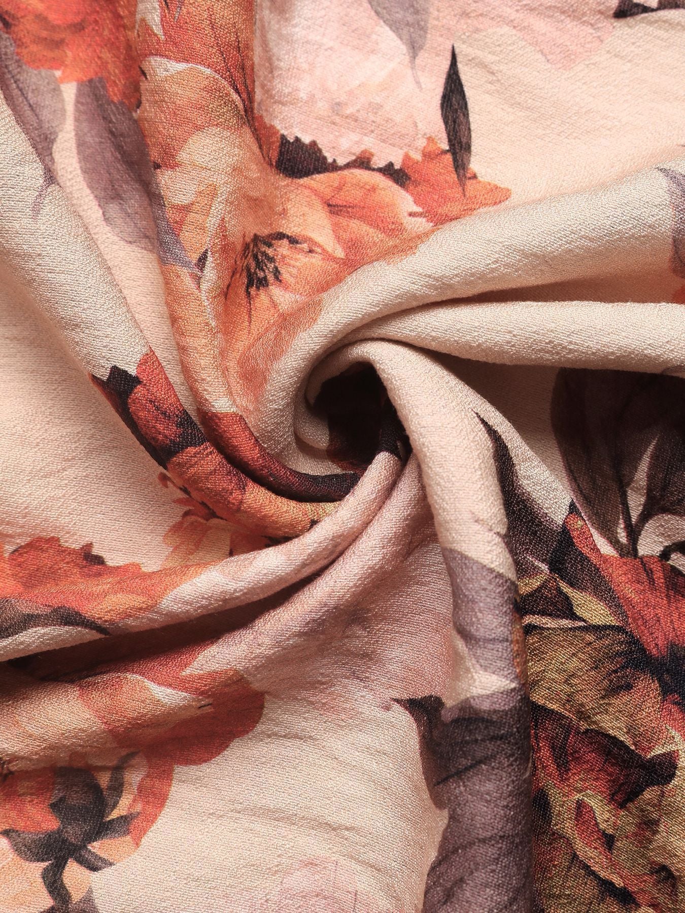 Close-up of floral fabric with orange, black, and beige colors.
