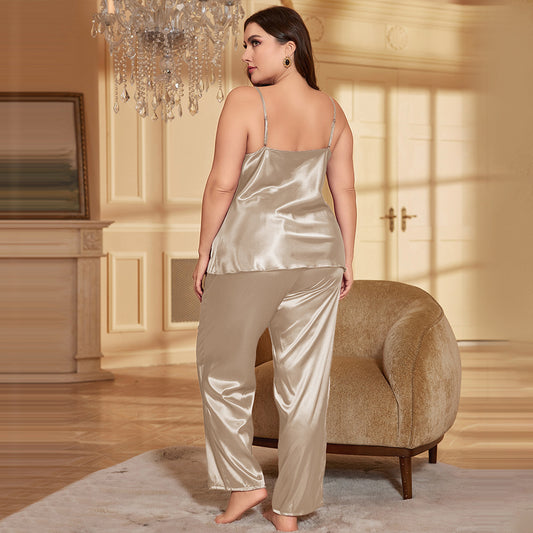 Woman wearing a satin pajama set in a luxurious room with a chandelier.