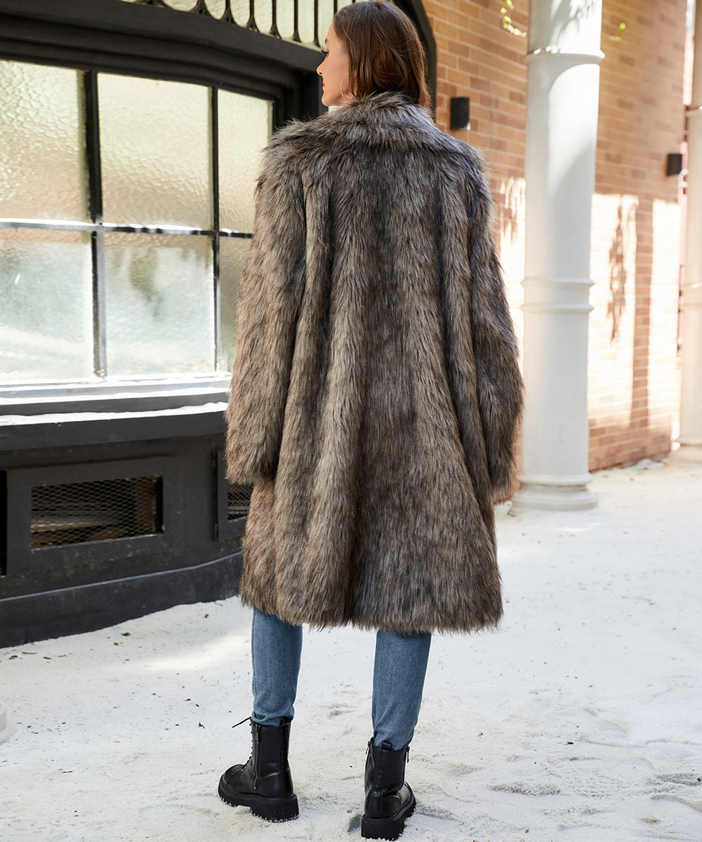 Person wearing a fur coat standing in front of a building with a snowy ground.