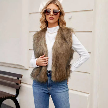 Woman wearing a fur vest, white sweater, and blue jeans with sunglasses indoors.