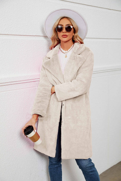 Woman wearing a beige coat and sunglasses, holding a coffee cup against a white background