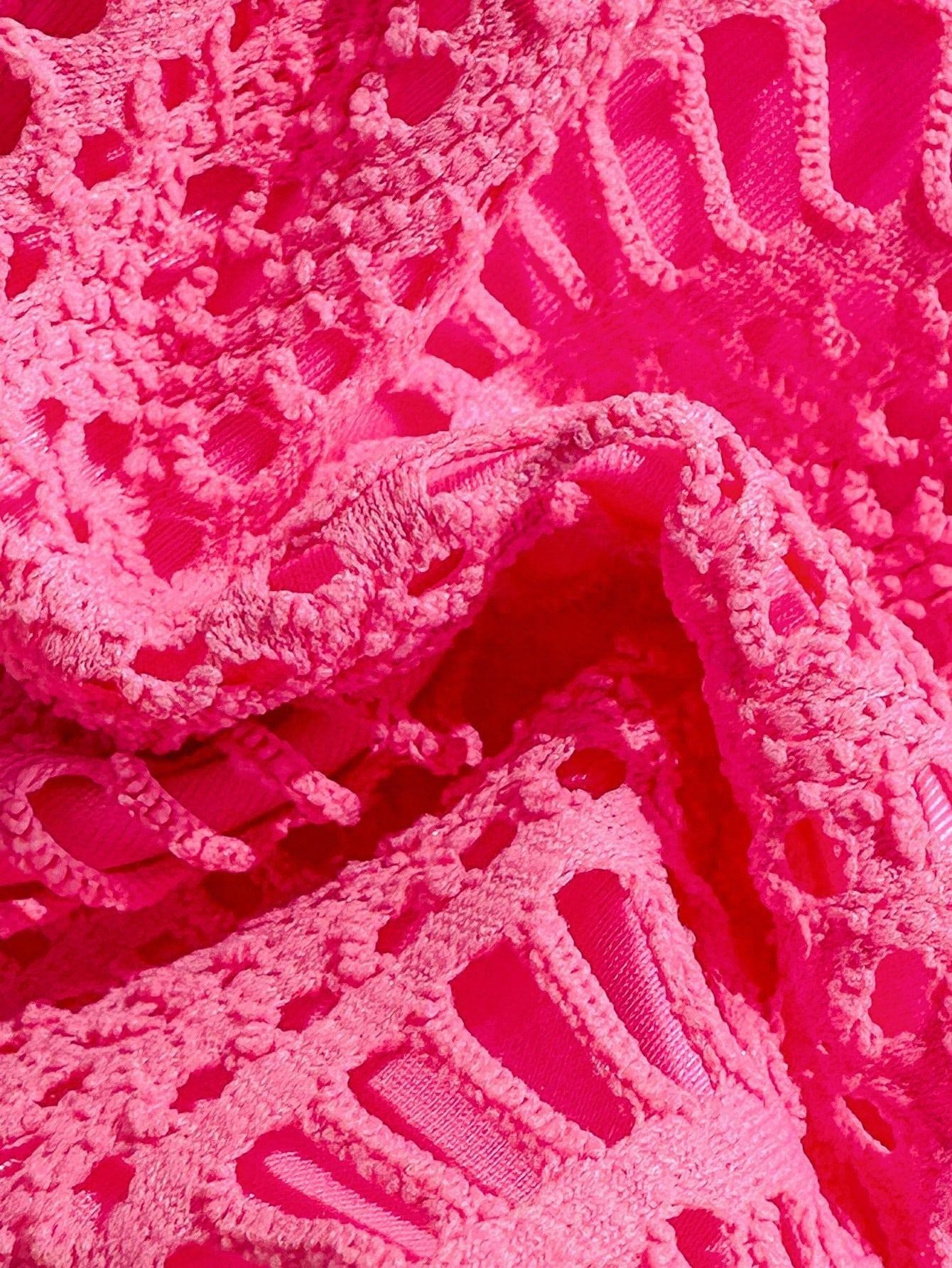 Close-up of pink lace fabric with intricate patterns