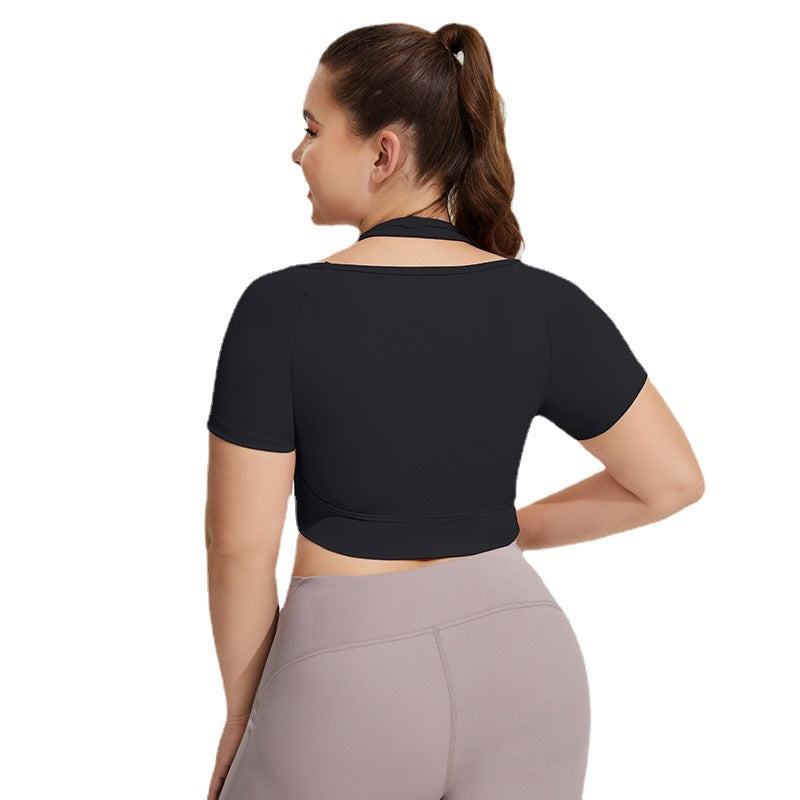 Woman wearing a black crop top and gray leggings on a white background