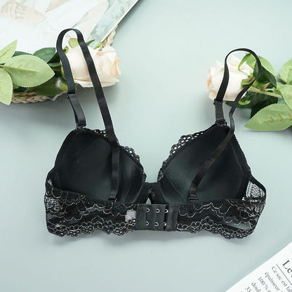 Black lace bra on a light blue background with greenery