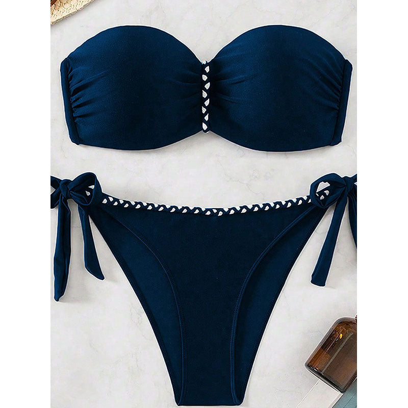 Navy blue bikini set with white embellishments on a light background