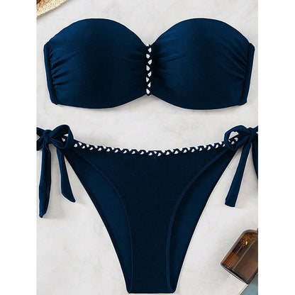 Navy blue bikini set with white embellishments on a light background