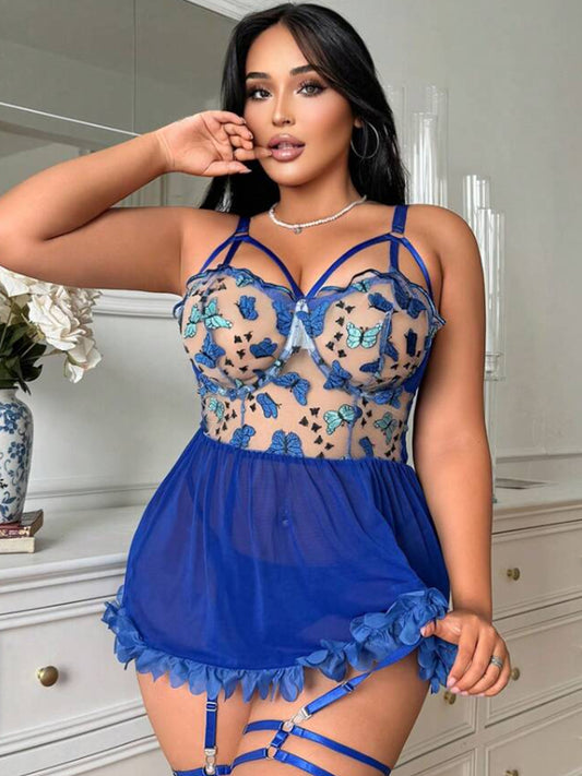 Woman wearing a blue lace lingerie set in a room with white furniture.