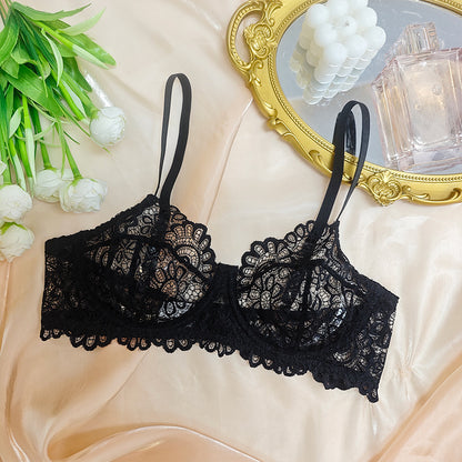 Black lace bra on a beige surface with decorative elements