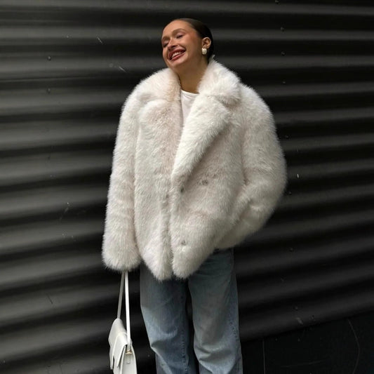 Person wearing a fluffy white coat against a corrugated metal background