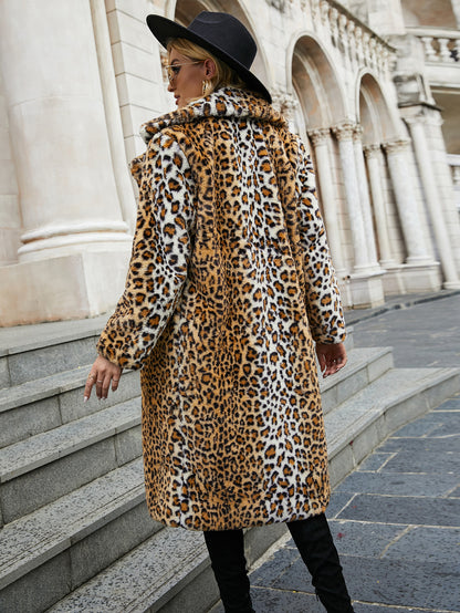 Person wearing a leopard print coat and black hat in an urban setting