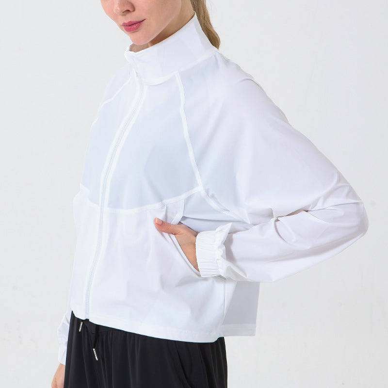 Person wearing a white long-sleeve shirt with a high collar on a plain background