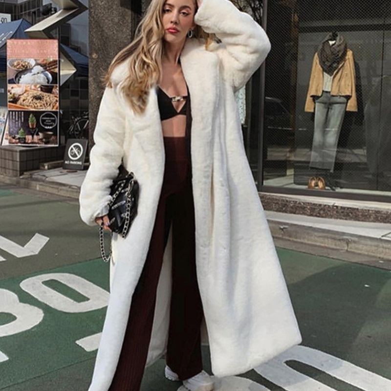 Woman wearing a long white fur coat in an urban setting