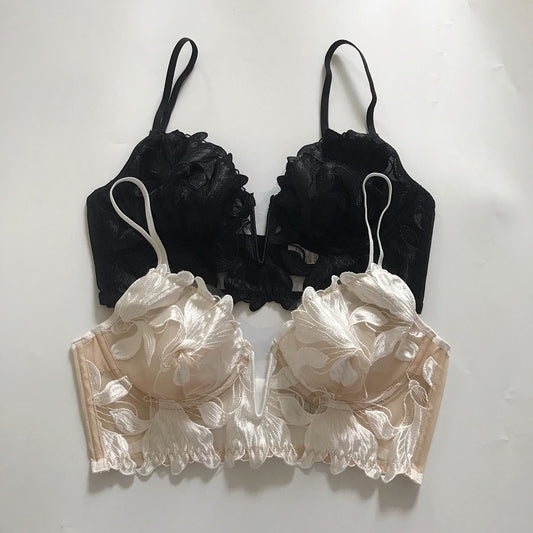 Black and beige floral lace bras on a white background