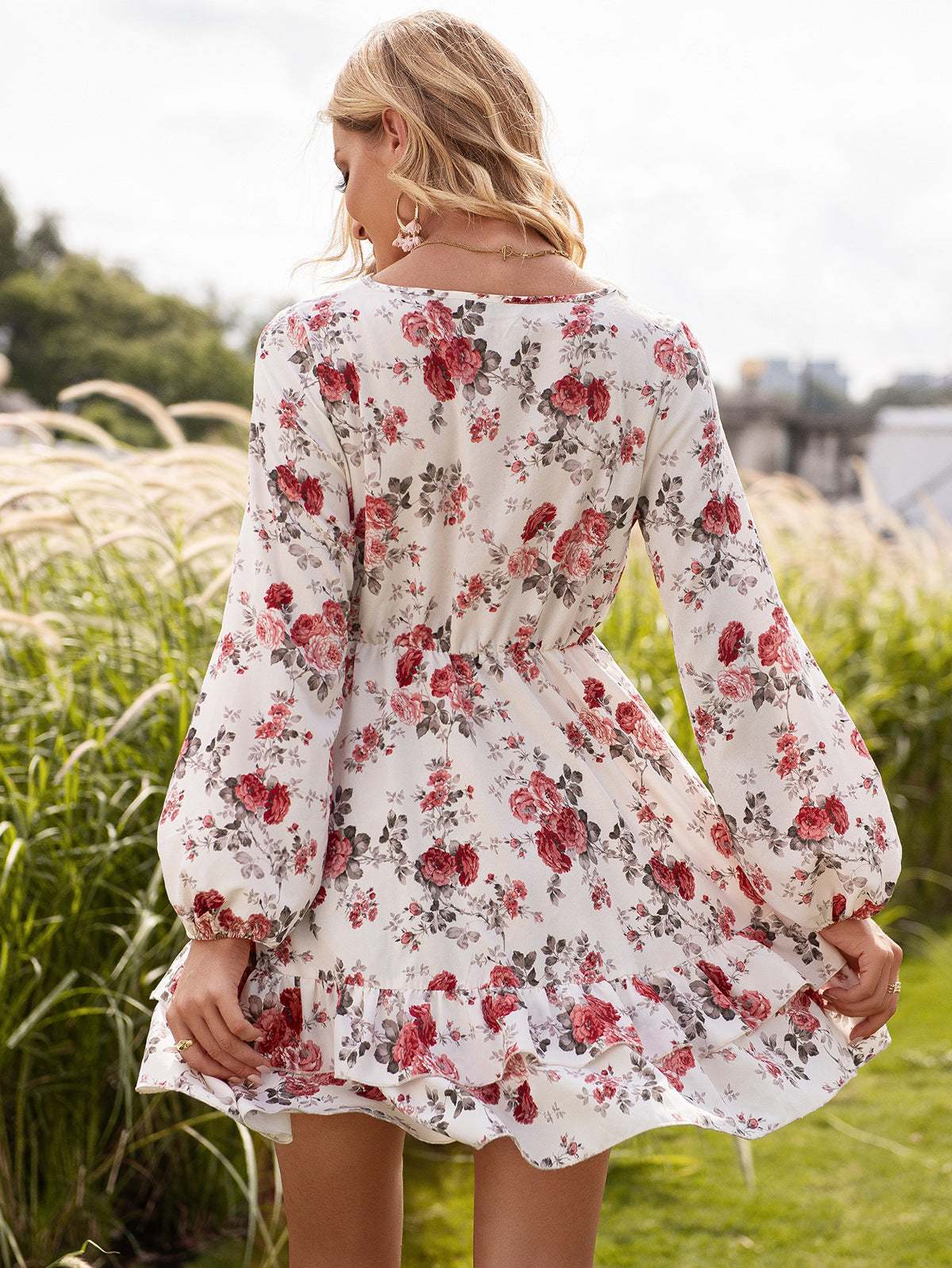 Woman wearing a floral dress standing in a grassy field