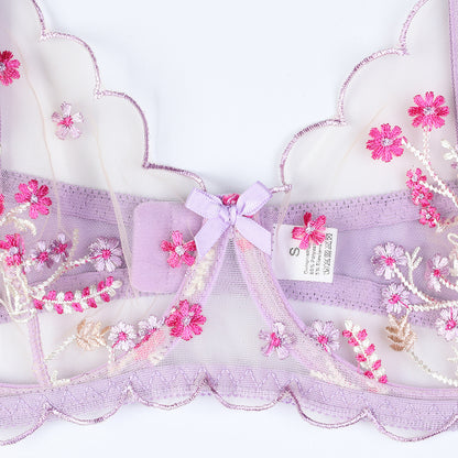 Embroidered fabric with pink flowers and a bow on a white background