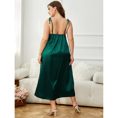 Woman wearing a green satin nightgown in a room with white walls and furniture.