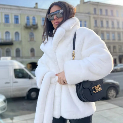 Woman wearing a white fur coat and sunglasses in an urban setting