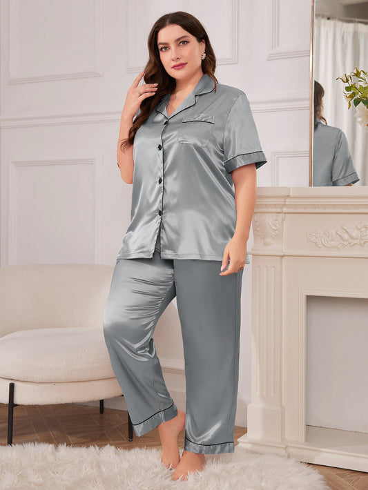 Woman wearing a gray satin pajama set in a cozy room.
