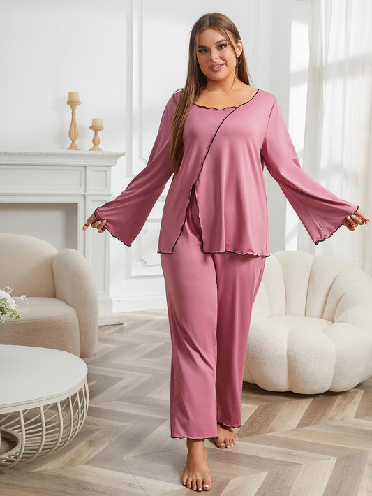 Woman wearing a pink pajama set in a cozy living room.